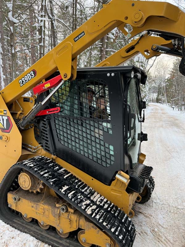 a skid loader plowing snow