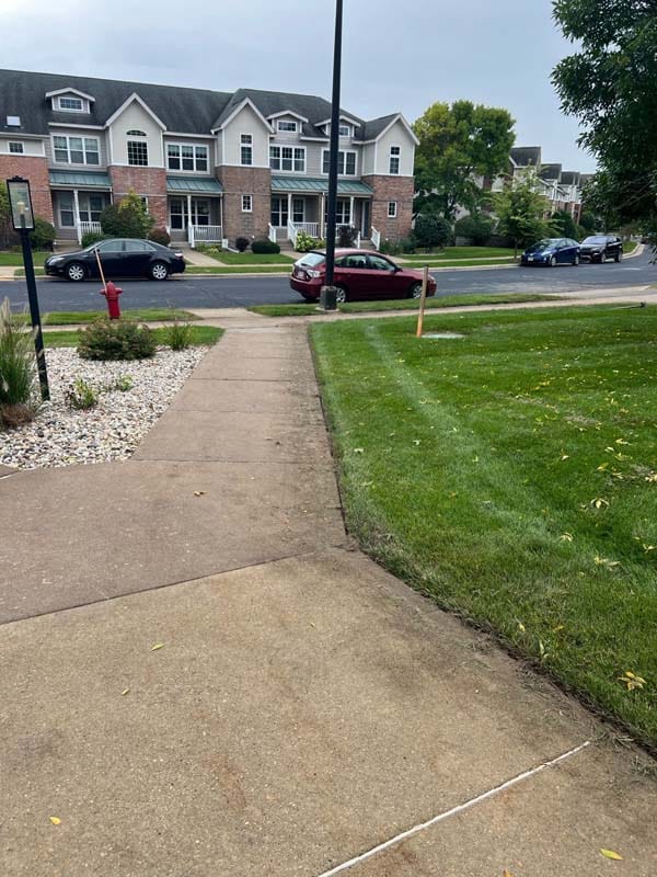 a sidewalk with grass on either side