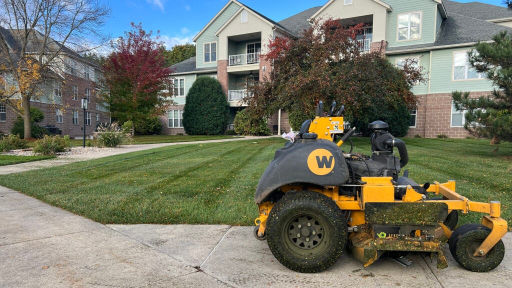 a lawnmower parked near a freshly mowed lawn