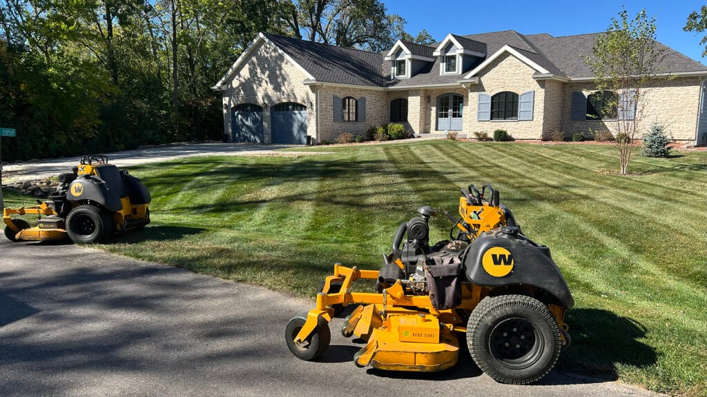 a lawnmower parked near a freshly mowed lawn