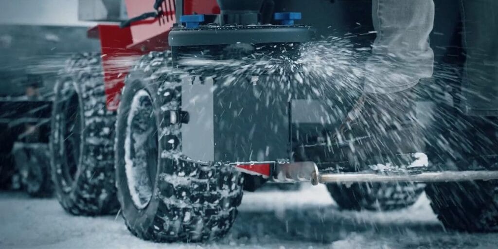 a snow plow adding salt to a road