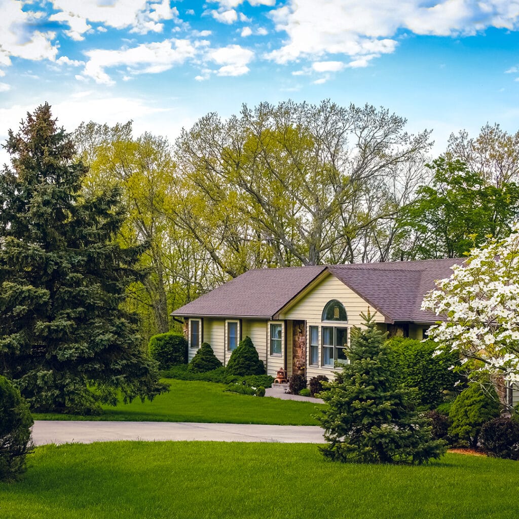a landscaped home with green lawn